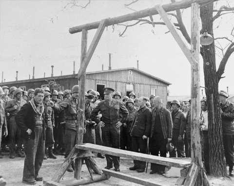 During an official tour of the newly liberated Ohrdruf concentration camp, an Austrian Jewish survivor describes to General Dwight Eisenhower and the members of his entourage the use of the gallows in the camp. Credit: National Archives and Records Administration, College Park United States Holocaust Memorial Museum, courtesy of David Wherry